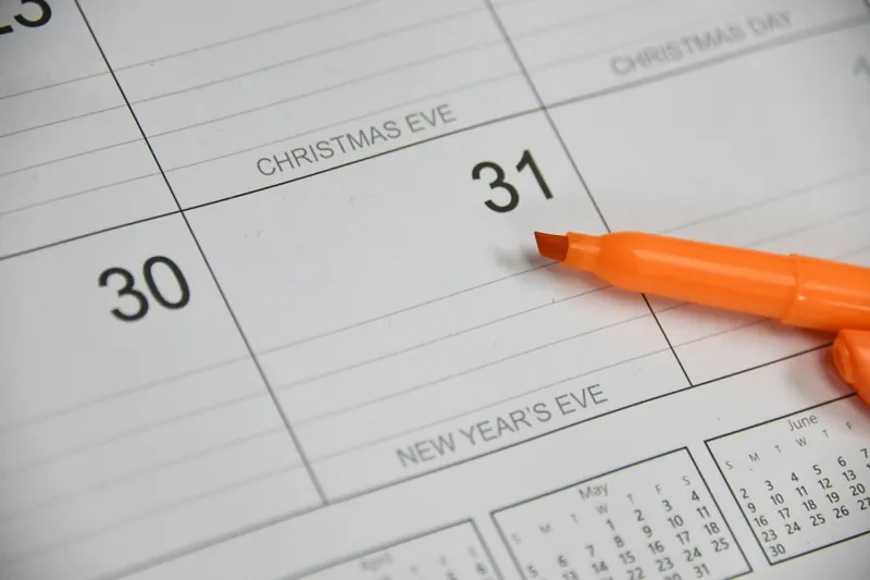 Orange highlighter resting beside the 31st on a paper calendar page
